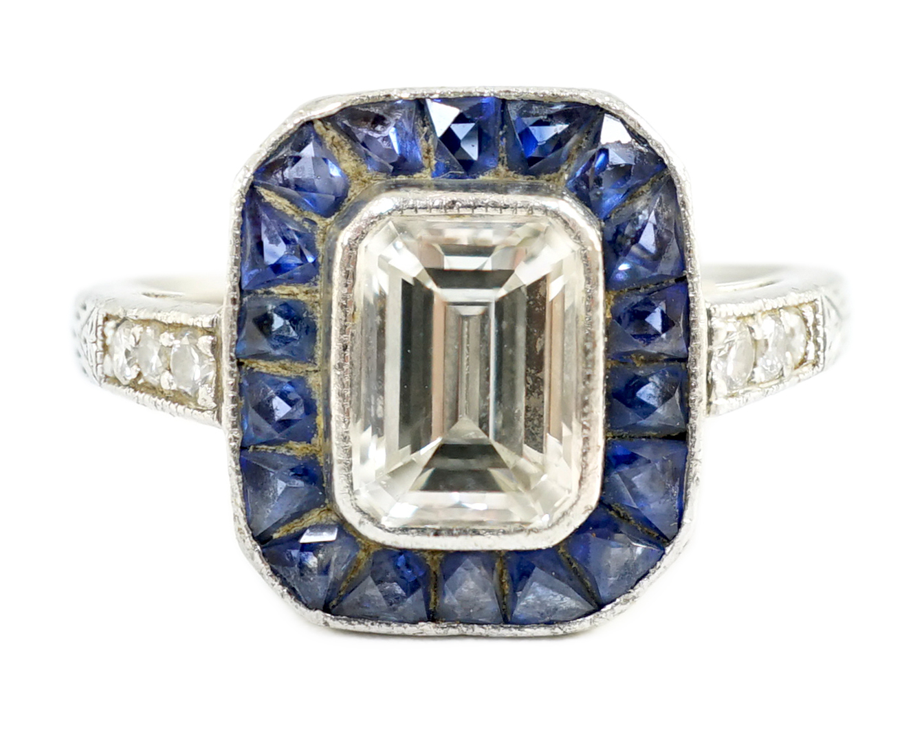 A 1920's platinum and millegrain set single stone emerald cut diamond and sapphire set rectangular cluster ring